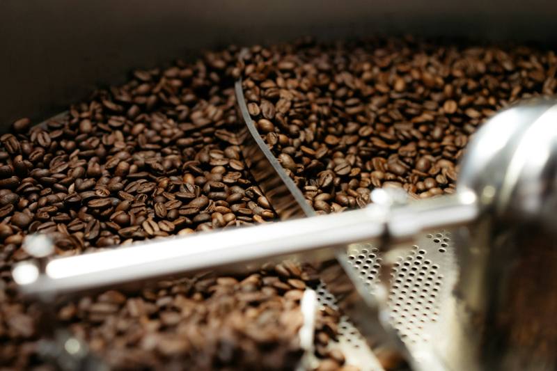 Freshly roasted coffee beans turning in a roaster